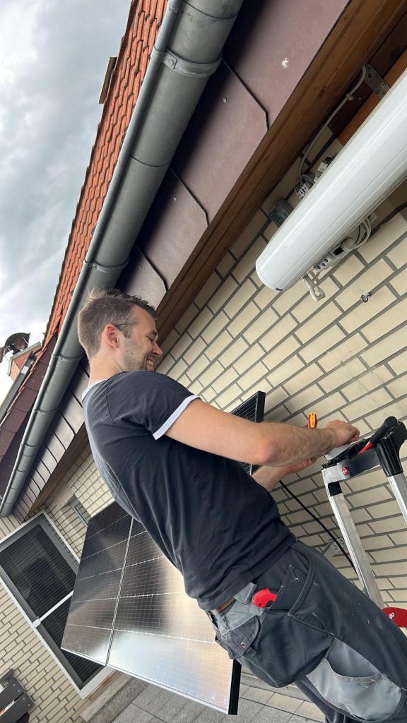 Monteur bei der Installation eines Balkonkraftwerkes.